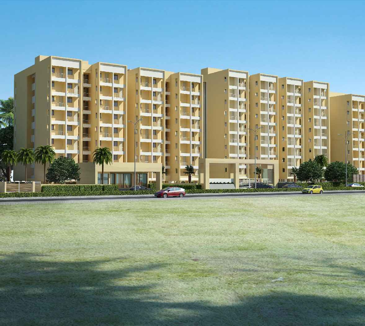 Modern yellow apartment complex with balconies, palm trees, and parked cars, set against a clear blue sky | Karamchand Properties